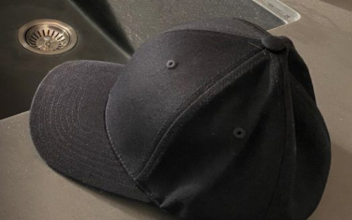 A black cloth baseball cap on a countertop