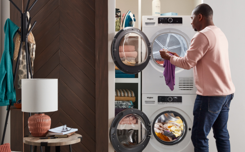 A man pulling a piece of clothing out of the dryer