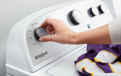 A person adjusting Whirlpool washer’s settings