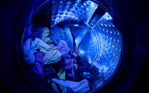 Inside a Whirlpool®  Washer basket with UV Clean Technology shining a blue UV light