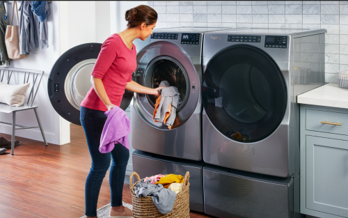 Person loading items into a front load washing machine