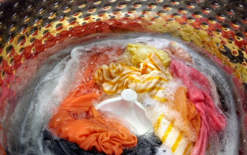 Clothing in washer drum sitting in soapy water