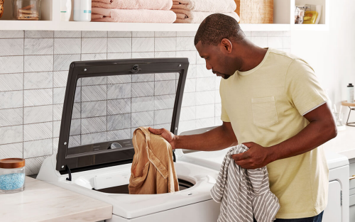 A person taking laundry out of a washer