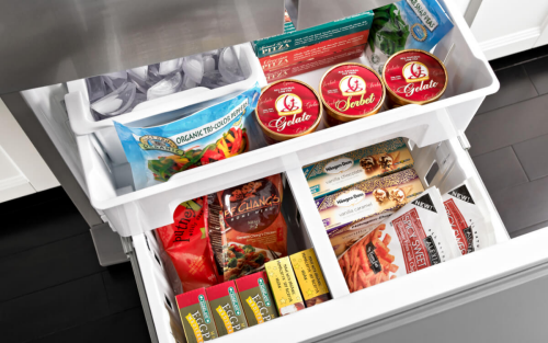 White freezer drawers opened showing a variety of frozen foods