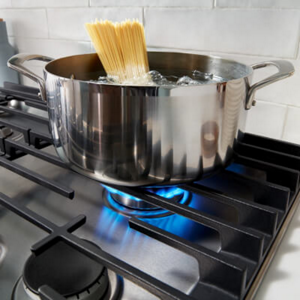 Pasta in a pot of water on a gas cooktop