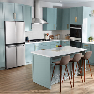 A bright kitchen with blue cabinets, a cooktop and stainless steel Whirlpool® Appliances