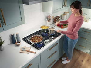 A woman cooking at a gas cooktop