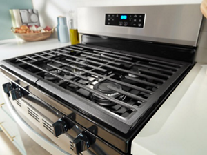 Close up of a gas stovetop showing cast iron grates and gas stove burners
