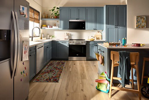 A suite of Whirlpool® stainless steel appliances in a cornflower blue kitchen