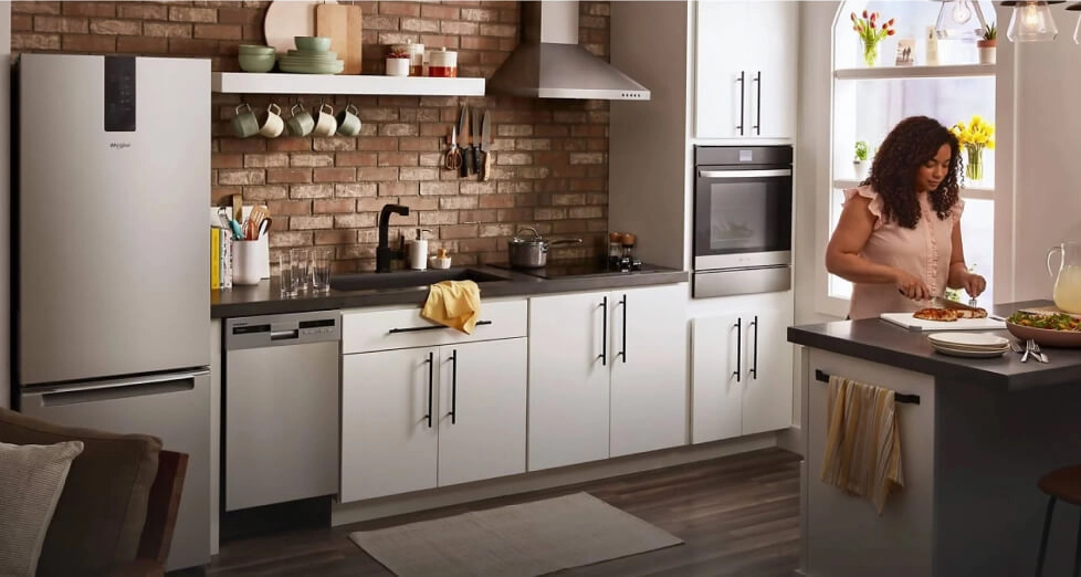 A person cutting chicken on a counter.