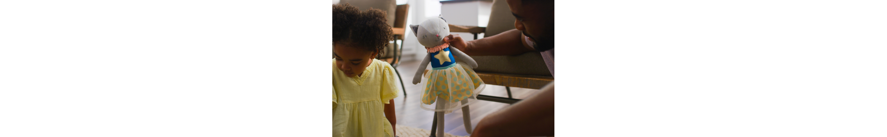 Father handing stuffed animal to daughter