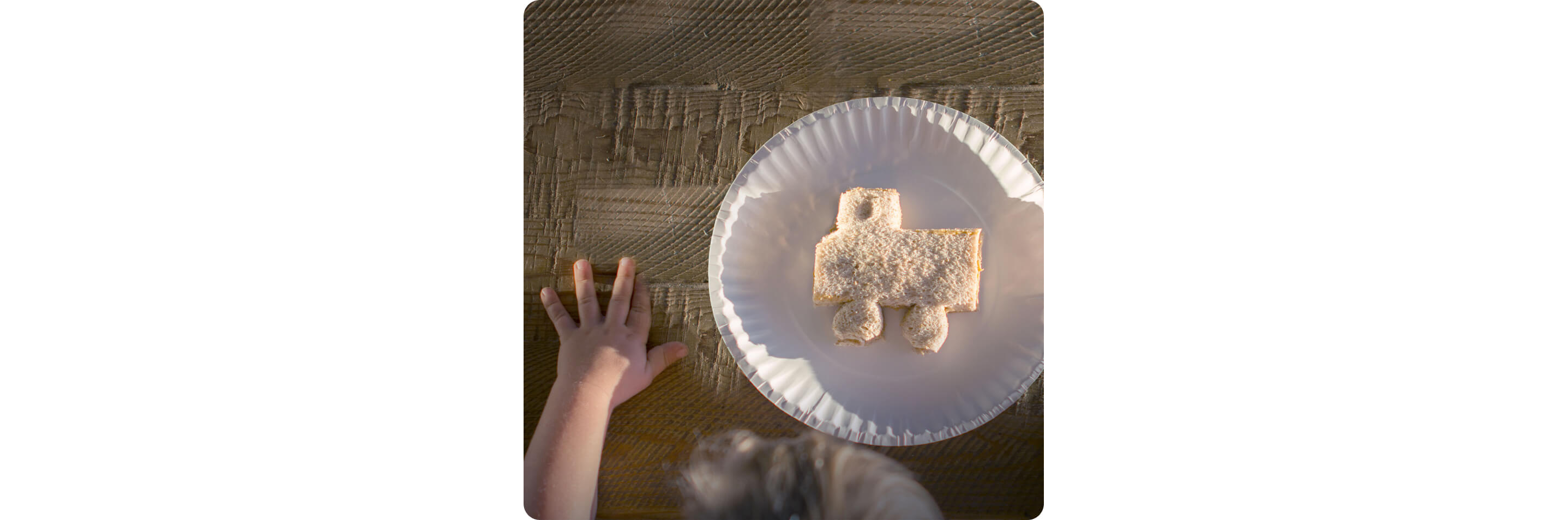 A child with a sandwich cut into the shape of a car