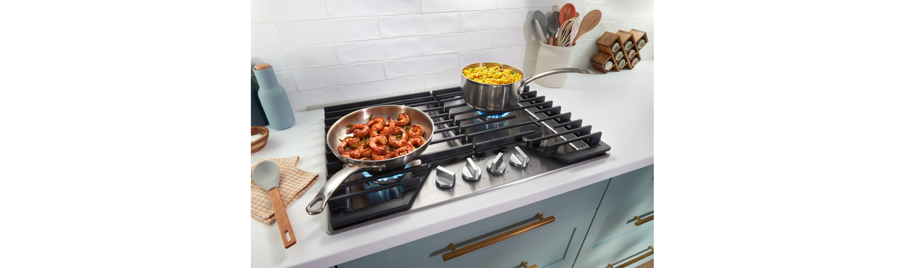 Pots and pans cooking on a gas cooktop.