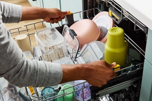 Person adjusting the height of a third rack inside a dishwasher