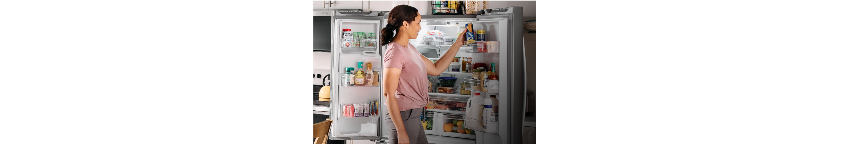 A person grabbing an item from a Whirlpool® refrigerator with the Whirlpool® home heartbeat appliance blog logo