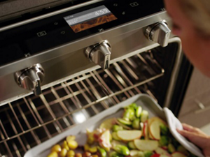 Someone pulling a sheet pan of food out of an oven