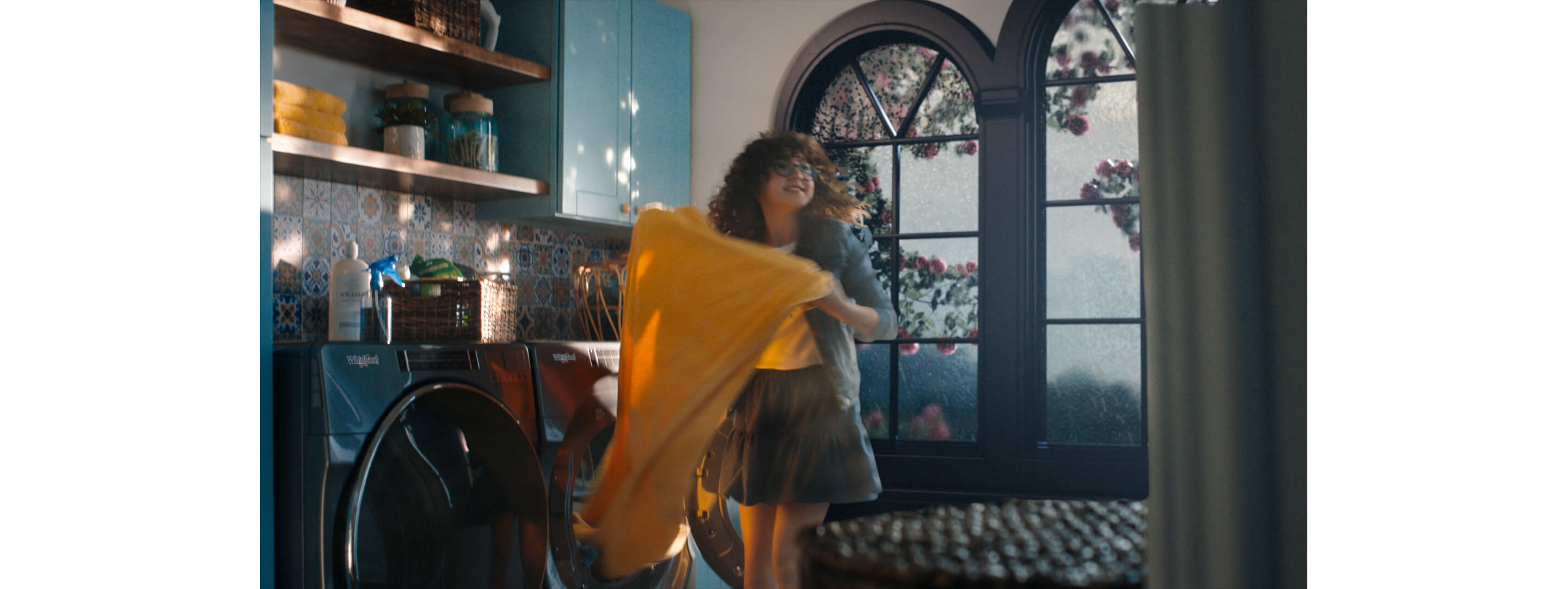A woman taking a blanket out of a Whirlpool® Dryer