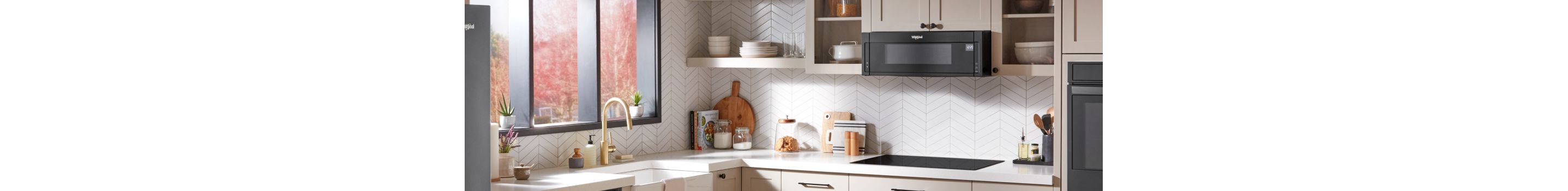 A black Whirlpool® Low Profile Over-The-Range microwave in a modern kitchen