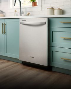 A closed stainless steel dishwasher in a kitchen with teal cabinets and brass hardware