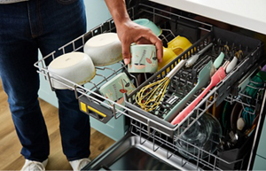 An open Whirlpool® Washing 3rd level rack with dishes arranged and ready for cleaning