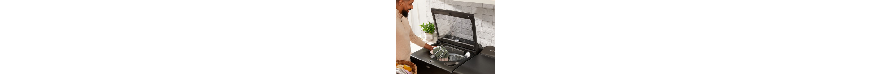 Person loading laundry in a top load washer