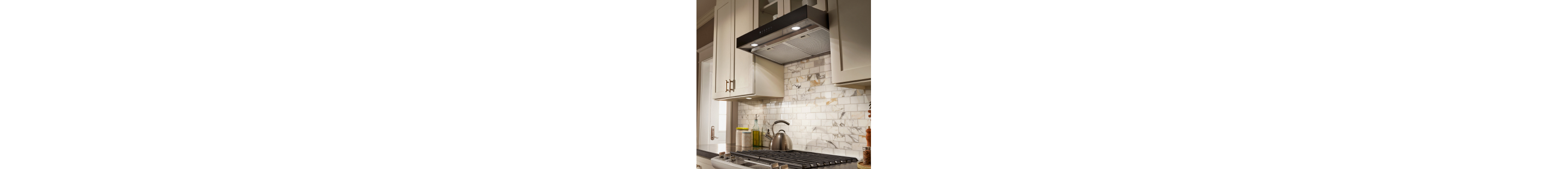 Gas cooktop and stainless steel range hood in white kitchen
