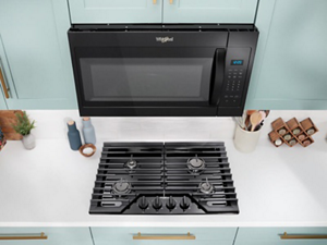 A Whirlpool® Microwave above a Whirlpool® Cooktop
