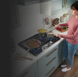 A person cooking on a Whirlpool® Cooktop