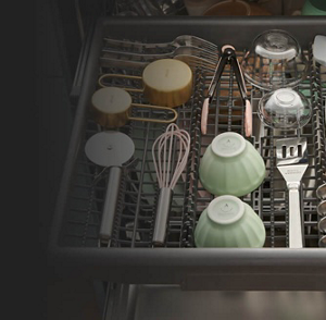 A dishwasher third rack loaded with utensils, small bowls and spoons