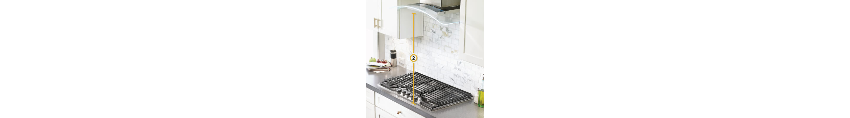 Gas cooktop set into gray countertop with measurements noted for distance from cooking surface to vent hood