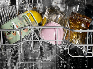 Water spraying glasses and mugs on an upper dishwasher rack