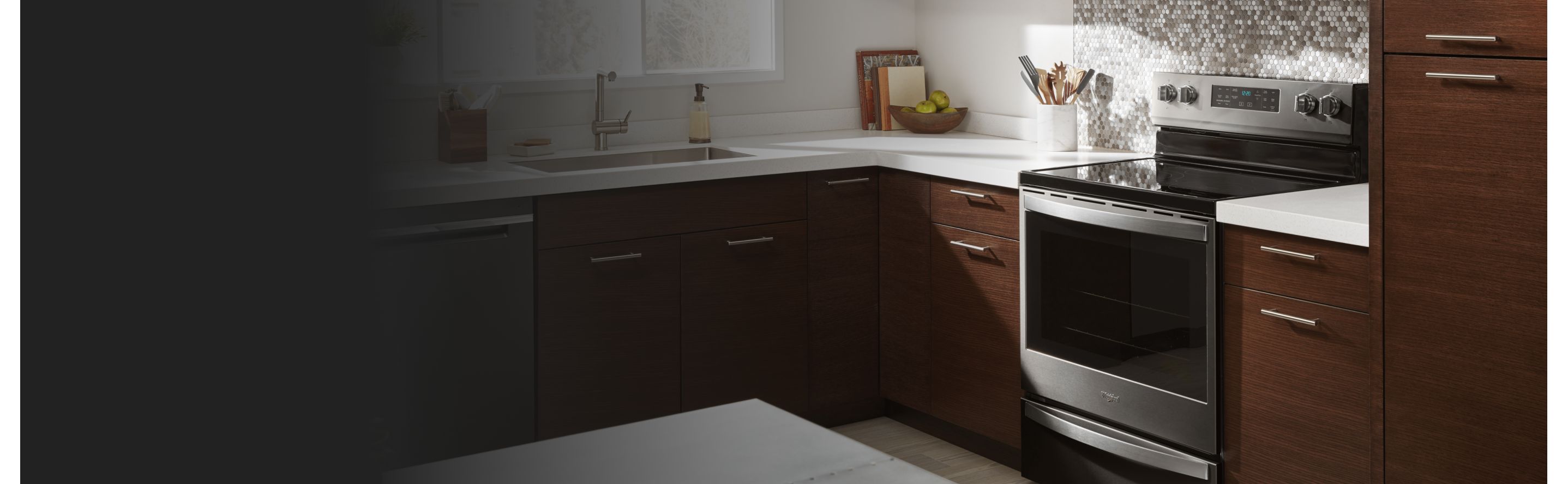 Silver and black electric stove surrounded by brown cabinetry
