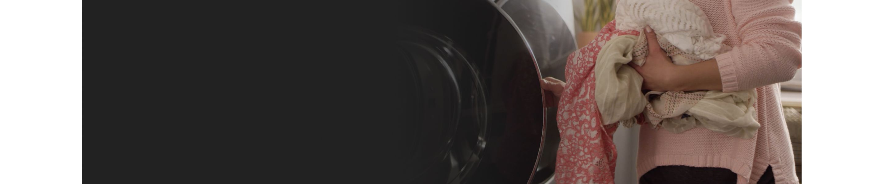 Woman loading clothes into high capacity front load washer