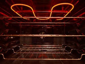 The inside of an empty oven with the burners glowing