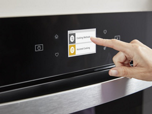A person using the control panel to select their oven settings