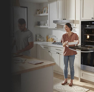 A woman pulling a pan out of her wall oven