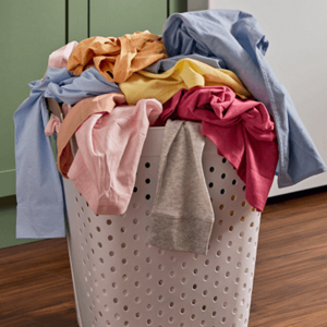 A laundry basket filled with mixed clothes