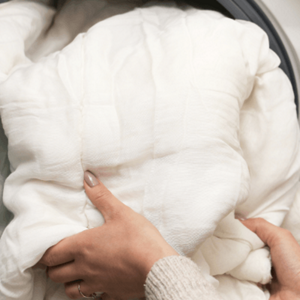 Someone handling a comforter in their laundry