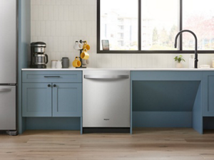 The inside of a kitchen with blue cabinetry and a stainless steel dishwasher