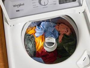 An open washer with clothes inside