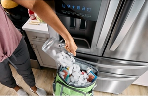 A person filling a cooler with ice cubes from their Whirlpool® Refrigerator's ice dispenser